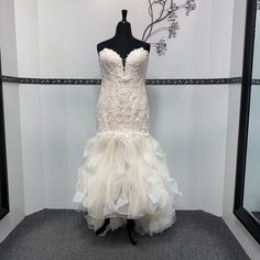 a wedding dress is displayed on a mannequin in front of a wall with mirrors