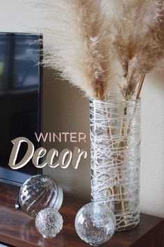 there is a vase with some dry grass in it and the words winter decor above it