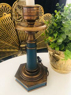 a candle holder sitting on top of a table next to a potted plant