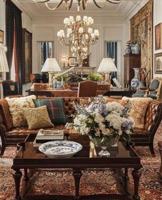 a living room filled with lots of furniture and a chandelier hanging from the ceiling