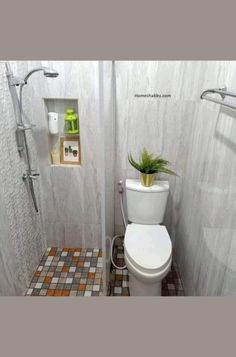 a bathroom with a toilet, shower head and tiled floored walls is shown in this image