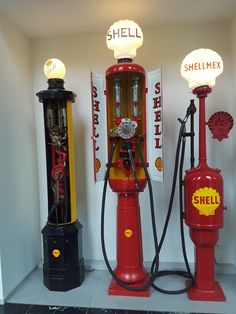 three red and yellow fire hydrants sitting next to each other in a white room