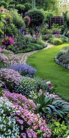 a garden filled with lots of different types of flowers and plants on top of green grass