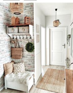 a white bench sitting in the middle of a room next to a brick wall with baskets on it