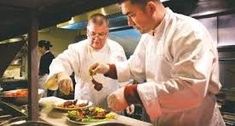 two chefs are preparing food in the kitchen