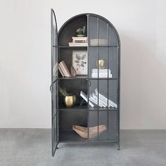 a book shelf with several books on it and a vase in the corner next to it