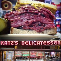 a large roast beef sandwich sitting on top of a plate in front of a store