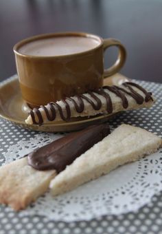 a cup of coffee and some cookies on a table