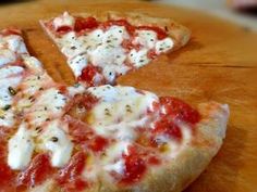 two slices of pizza sitting on top of a wooden cutting board with cheese and sauce