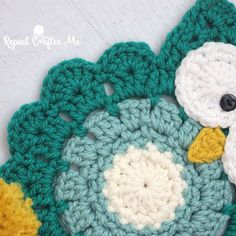 a crocheted owl is sitting on top of a green and white doily