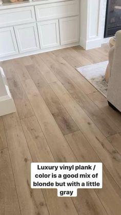 a living room with wood floors and white cabinets in the background, text reads luxury vinyl plank / color is a good mix of blonde but with a little gray