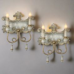 two wall sconces with lit candles on them