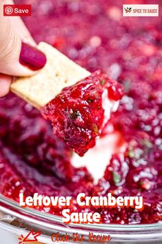 a person dipping cranberry sauce into crackers in a bowl with the words leftover cranberry sauce on it