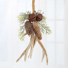 an ornament with antlers and pine cones hanging from a rope