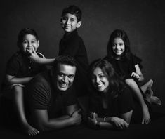 a family poses for a black and white photo with their two children in the middle