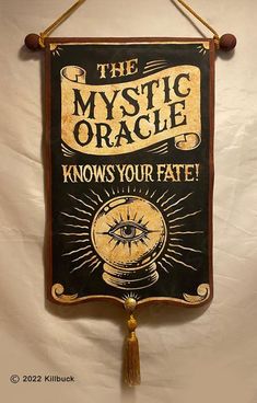 the mystic oracle knows your fate sign hanging on a wall with a tasseled cord