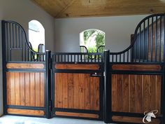 the inside of a horse stable with wooden doors and rails on each side of it