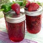 two jars filled with jam sitting on top of a table