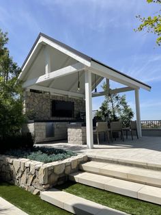 an outdoor kitchen with stone steps leading up to it and a grill area on the other side