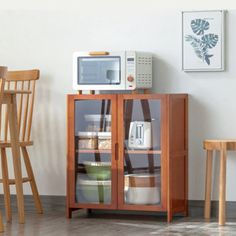 a microwave oven sitting on top of a wooden cabinet next to a dining room table