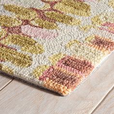 an area rug is shown on the floor with white wood planks and light colored carpeting