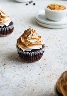 several cupcakes with frosting and peanut butter on top are sitting on a table