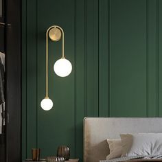 a bedroom with green walls and two lights hanging from the ceiling, along with a bed