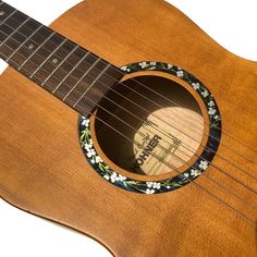 an acoustic guitar with a floral design on it