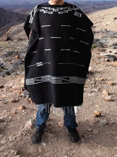 Material: Acrylic WoolColor: BlackStyle: Mexican Design: Clint EaswoodSize:Length: 192cm (75")Width: 112 cm (44")It refers to the total measurements of the poncho when it is fully open (like a blanket). Description: MEXICAN PONCHO Discover the iconic Mexican Poncho Clint Eastwood made famous. This timeless garment has been a symbol of rugged style and effortless cool. Crafted with authentic Mexican craftsmanship, our Mexican Poncho captures the essence of Clint Eastwood's classic western films. Clint Eastwood Poncho, Poncho For Men, Poncho Mexican, Mens Poncho, Artisanal Design, Mexican Designs, Rugged Style, Authentic Mexican, Poncho Style