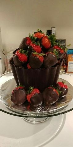 chocolate covered strawberries sit on top of a glass platter in front of a microwave