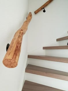 a wooden object hanging on the wall next to some stairs