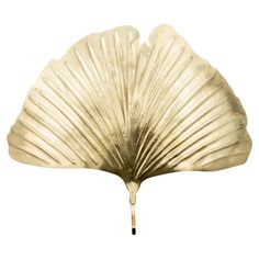 a gold leaf shaped object on a white background