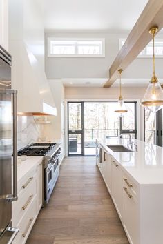 a kitchen with white cabinets and wood floors