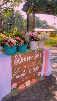 a sign that says bloom bar please make and take a bouquet on the table with potted flowers