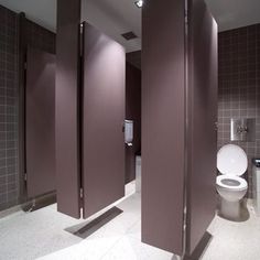 three stalls in a bathroom with toilet and urinals