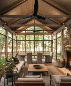 a living room filled with lots of furniture and a fire place under a ceiling fan