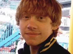 a close up of a person wearing a black jacket and striped scarf with stairs in the background