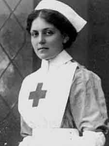 an old black and white photo of a woman wearing a nurse's outfit with a cross on it