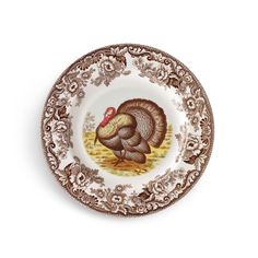 a plate with a turkey painted on it's side and gold trimming around the edge