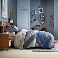 a bedroom with blue walls and furniture in the corner, including a bed that has a quilt on it