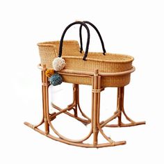 two wicker baby cradles with black handles and white balls on the handlebars