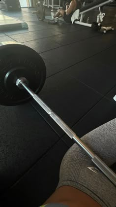 a man is doing squats with a barbell in his hand at the gym