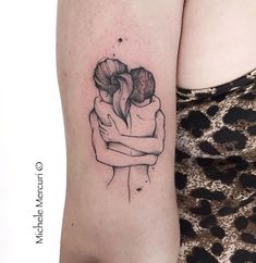 a woman's arm with a tattoo on it that has two people hugging each other