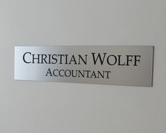 a sign that says christian wolf account on the side of a white wall with black lettering