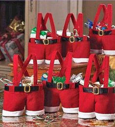 several red bags with santa claus's hats on them sitting next to christmas decorations