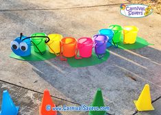 a group of plastic cups sitting on top of a cement floor next to colorful cones