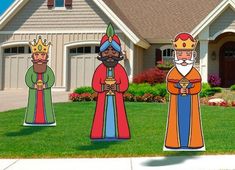 three paper cutouts of king and queen standing in front of a house