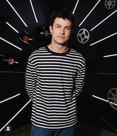 a young man standing in front of a black and white background