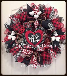 a red and black mesh wreath with a heart on the front door for valentine's day