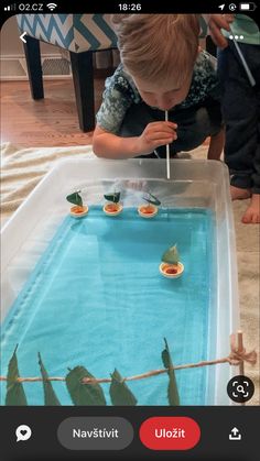 a young boy is playing with an aquarium